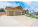 House exterior showcasing a three-car garage and well-maintained lawn at 3995 Manorbrier Cir, Castle Rock, CO 80104