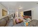 Open basement area with sectional sofa, stairs to main floor, and a large TV at 2166 S Joplin Way, Aurora, CO 80013