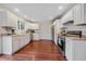 Well-lit kitchen features white cabinetry, stainless steel appliances, wood floors, and plenty of counter space at 2166 S Joplin Way, Aurora, CO 80013