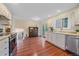 Open kitchen with white cabinets, stainless steel appliances, wood floors, and access to the living spaces at 2166 S Joplin Way, Aurora, CO 80013