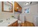 Convenient laundry room features a sink, mirror, wood cabinets, and a washer and dryer for added convenience at 2166 S Joplin Way, Aurora, CO 80013