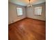 Bedroom with hardwood floors, plaster wall issues, and a vintage chandelier at 460 Yates St, Denver, CO 80204