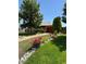 Charming home with lovely landscaping, beautiful flowers, mature trees, and a red garage door at 460 Yates St, Denver, CO 80204