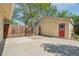 View of the fenced backyard and garage with a red door at 943 Pinon Ct, Longmont, CO 80504
