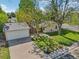 Aerial view of a quaint home with a detached garage, driveway, and mature trees at 943 Pinon Ct, Longmont, CO 80504