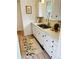 Bright kitchen featuring white cabinets, stainless steel sink, and floral accent rug at 943 Pinon Ct, Longmont, CO 80504