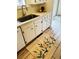 Bright kitchen featuring white cabinets, stainless steel sink, and floral accent rug at 943 Pinon Ct, Longmont, CO 80504