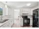 Charming kitchen featuring a black oven, white cabinets, and bright natural light at 943 Pinon Ct, Longmont, CO 80504