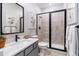 Modern bathroom features a walk-in shower with black trim, gray vanity, and contemporary fixtures at 16648 W 92Nd Pl, Arvada, CO 80007