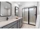 Modern bathroom features double sinks, sleek black hardware, and a glass-enclosed shower at 16648 W 92Nd Pl, Arvada, CO 80007