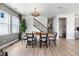 Light-filled dining room with a table set for six, modern chandelier, and view of the staircase at 16648 W 92Nd Pl, Arvada, CO 80007