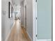 Bright hallway with wood floors leads to a living area, with clean white walls, a modern design and lighting at 16648 W 92Nd Pl, Arvada, CO 80007