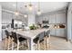 Open kitchen features gray cabinets, stainless steel appliances, quartz countertops, and large island with seating at 16648 W 92Nd Pl, Arvada, CO 80007
