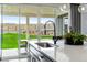 Close-up of a kitchen sink overlooking the backyard with outdoor seating and landscaping at 16648 W 92Nd Pl, Arvada, CO 80007