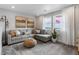 Comfortable living room with a gray sectional, textured wallpaper, and scenic views from the large windows at 16648 W 92Nd Pl, Arvada, CO 80007
