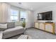Stylish living room with a gray sofa, a modern media cabinet, and bright natural light at 16648 W 92Nd Pl, Arvada, CO 80007