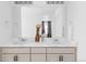 Bright bathroom featuring a double vanity with modern fixtures and a large mirror at 6117 Easton Cir, Frederick, CO 80504
