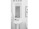 Compact bathroom featuring a pedestal sink, mirrored wall cabinet, and simple decor at 6117 Easton Cir, Frederick, CO 80504