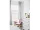 Cozy bedroom corner with a pink chair, white dresser, and soft natural light at 6117 Easton Cir, Frederick, CO 80504