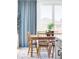 Cozy dining area with natural light, a wooden table, and stylish blue curtains at 6117 Easton Cir, Frederick, CO 80504