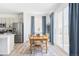 Bright dining room featuring a wooden table, blue curtains, and sliding glass doors to an outdoor patio at 6117 Easton Cir, Frederick, CO 80504