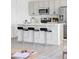 Bright kitchen featuring stainless steel appliances, white countertops and modern bar stools at 6117 Easton Cir, Frederick, CO 80504