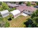 Aerial view of backyard with storage buildings, carport and brick home at 3055 S Winona Ct, Denver, CO 80236