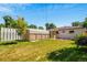 View of backyard with two storage buildings, a carport and a brick home with windows at 3055 S Winona Ct, Denver, CO 80236