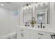 Bathroom featuring double vanity, two mirrors, and modern light fixture at 3055 S Winona Ct, Denver, CO 80236