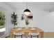 Cozy dining area with table set for four, modern light, and light wood floors at 3055 S Winona Ct, Denver, CO 80236
