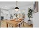 Bright dining area featuring a wooden table, modern light fixture, and access to outdoor area at 3055 S Winona Ct, Denver, CO 80236
