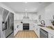 Modern kitchen with white cabinetry, stainless steel appliances and hardwood floor at 3055 S Winona Ct, Denver, CO 80236