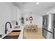 Modern kitchen with stainless steel appliances adjacent to a dining area at 3055 S Winona Ct, Denver, CO 80236