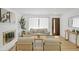 Bright living room with a fireplace, stylish furniture, and light wood floors at 3055 S Winona Ct, Denver, CO 80236