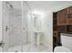 Bathroom featuring marble tiled shower and floors plus a white pedestal sink and wood shelving at 3746 S Fairplay Way, Aurora, CO 80014