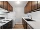 Bright kitchen with white appliances, dark cabinets, and a functional layout at 3746 S Fairplay Way, Aurora, CO 80014