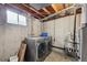 Unfinished basement laundry room with stainless steel washer/dryer and utility sink at 3746 S Fairplay Way, Aurora, CO 80014