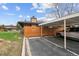 Assigned carport and parking space for home featuring partial wooden fence and lawn at 3746 S Fairplay Way, Aurora, CO 80014