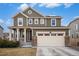 Traditional two-story home with a covered porch, two-car garage, and neatly manicured landscaping at 16317 Saint Paul St, Thornton, CO 80602