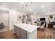 Bright kitchen with a center island, pendant lights, and seamless flow into the living area at 16317 Saint Paul St, Thornton, CO 80602