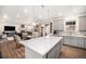 Open-concept kitchen with a large center island, pendant lighting, and modern gray cabinets at 16317 Saint Paul St, Thornton, CO 80602