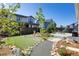 Professionally landscaped backyard featuring artificial turf, rock beds, stone walkway and grilling area at 11299 Star Streak Ln, Littleton, CO 80125