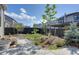 The backyard includes a stone walkway, artificial turf, a rock garden, a black fence and landscaping at 11299 Star Streak Ln, Littleton, CO 80125