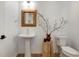Stylish powder room with pedestal sink, decorative mirror and wood accents at 11299 Star Streak Ln, Littleton, CO 80125