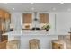 A close up of a kitchen island featuring stainless steel appliances, seating, with a light-filled dining area at 11299 Star Streak Ln, Littleton, CO 80125