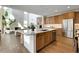 Modern kitchen with stainless steel appliances, a central island and hardwood floors, open to the living room at 11299 Star Streak Ln, Littleton, CO 80125