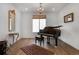 Elegant living room with a piano, chandelier, and large windows, ideal for entertaining at 11299 Star Streak Ln, Littleton, CO 80125