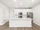 Modern white kitchen with stainless steel appliances, island with sink, and stylish backsplash at 754 N Tempe St, Aurora, CO 80018