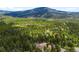 Picturesque aerial view of a wooded property nestled amongst lush trees with mountain views at 10090 Blue Sky Trl, Conifer, CO 80433