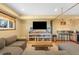 Finished basement area featuring a large couch, shelving, and a custom wet bar area at 10090 Blue Sky Trl, Conifer, CO 80433